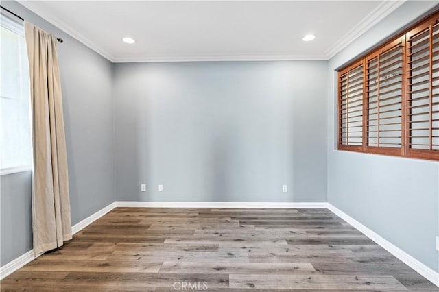 empty room featuring recessed lighting, baseboards, wood finished floors, and crown molding