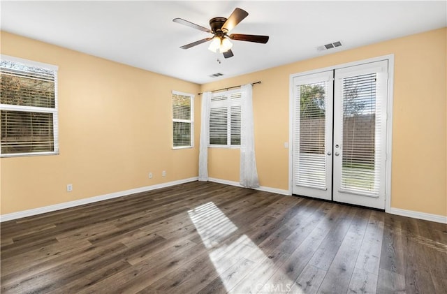 unfurnished room featuring ceiling fan, visible vents, baseboards, and wood finished floors