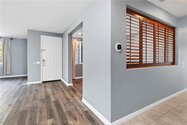 entrance foyer with baseboards and wood finished floors