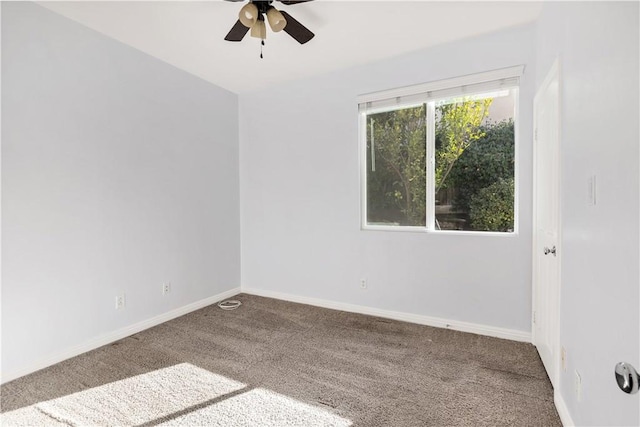 carpeted spare room with a ceiling fan and baseboards