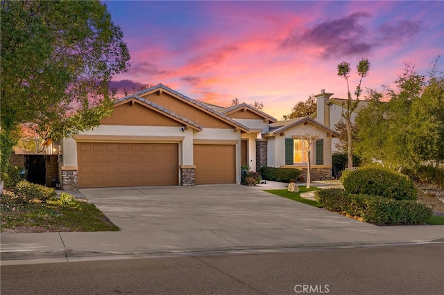 craftsman inspired home with stone siding, stucco siding, an attached garage, and concrete driveway