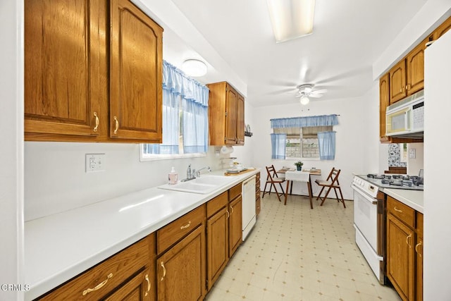 kitchen featuring ceiling fan, sink, and white appliances