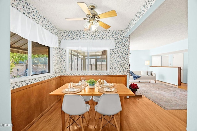 dining area with ceiling fan, wood-type flooring, a textured ceiling, and breakfast area