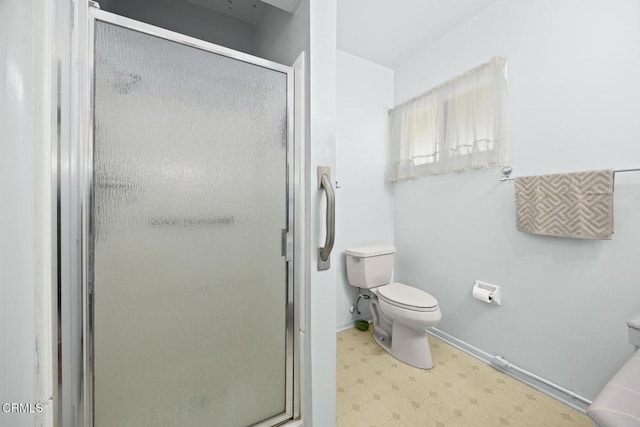 bathroom with toilet and a shower with door