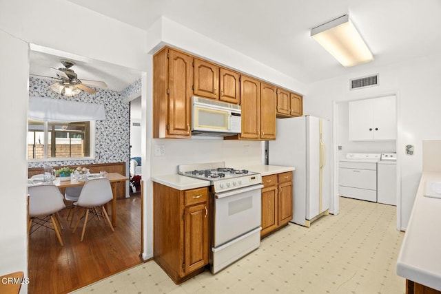 kitchen featuring ceiling fan, separate washer and dryer, and white appliances