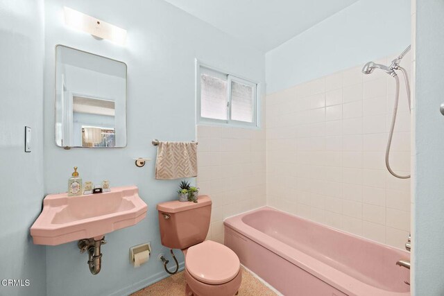 full bathroom featuring toilet, washtub / shower combination, and sink