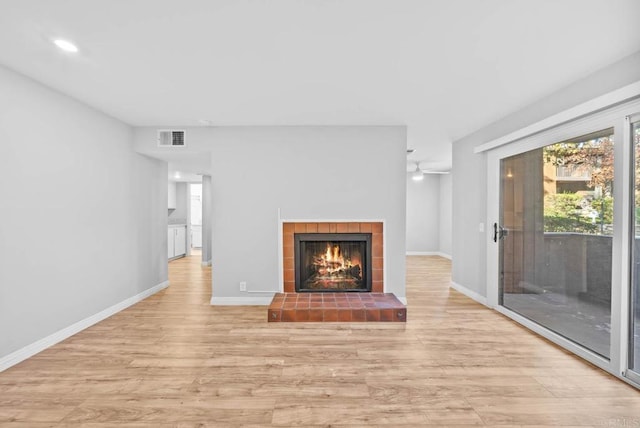 unfurnished living room featuring a fireplace and light hardwood / wood-style flooring