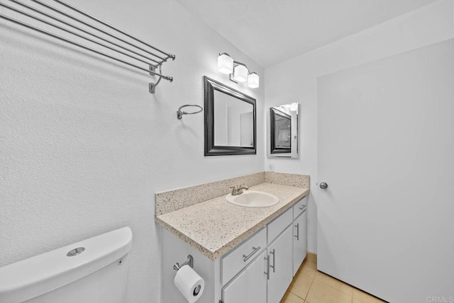 bathroom featuring toilet, vanity, and tile patterned floors