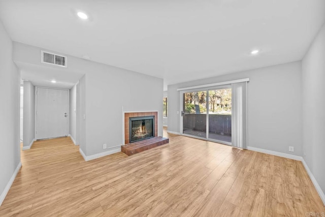 unfurnished living room with a fireplace and light hardwood / wood-style flooring