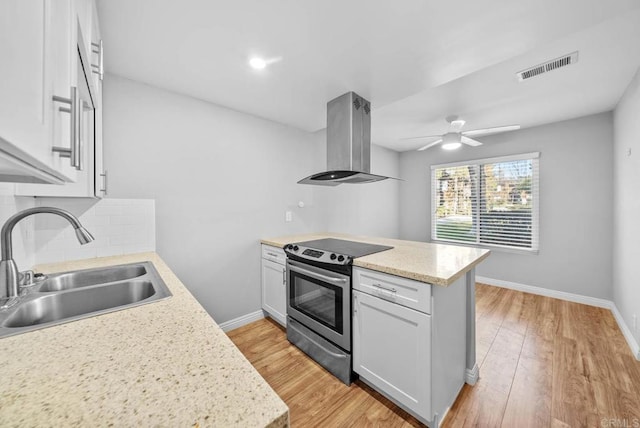 kitchen with sink, stainless steel electric range oven, white cabinets, and island range hood