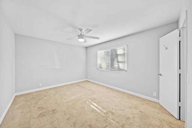 unfurnished room featuring ceiling fan and light carpet