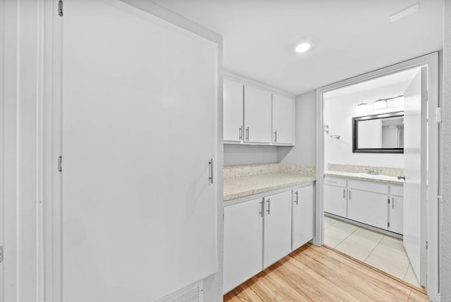 kitchen featuring white cabinets, sink, and light hardwood / wood-style flooring