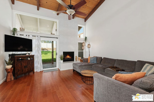 living room with hardwood / wood-style floors, beam ceiling, a large fireplace, wood ceiling, and high vaulted ceiling