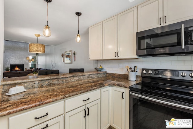 kitchen with dark stone counters, a fireplace, backsplash, hanging light fixtures, and range with electric stovetop