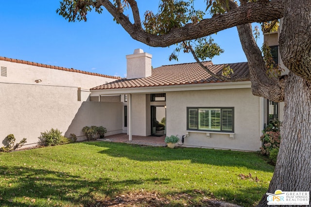 back of house with a lawn and a patio area