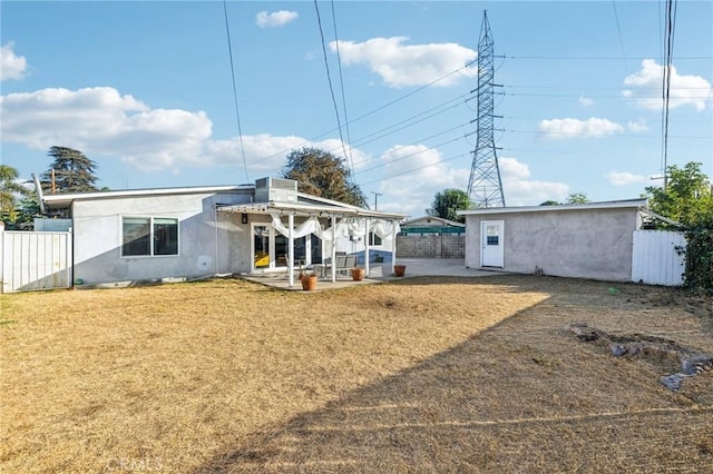 rear view of property featuring central air condition unit, a patio area, and a yard