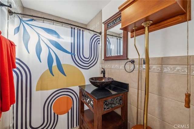 bathroom with tile walls, curtained shower, and sink