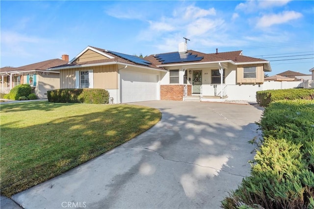 single story home featuring a garage, a front yard, and solar panels