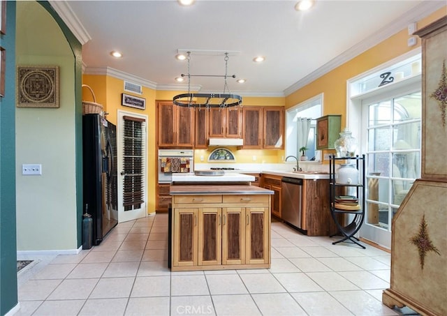 kitchen featuring black fridge, oven, a kitchen island, crown molding, and stainless steel dishwasher