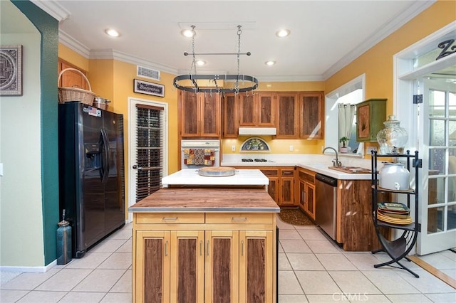 kitchen featuring black fridge, light tile patterned flooring, oven, stainless steel dishwasher, and a center island