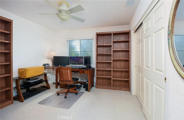 carpeted office space featuring ceiling fan