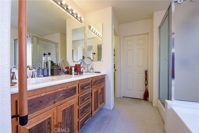 bathroom with vanity and shower with separate bathtub