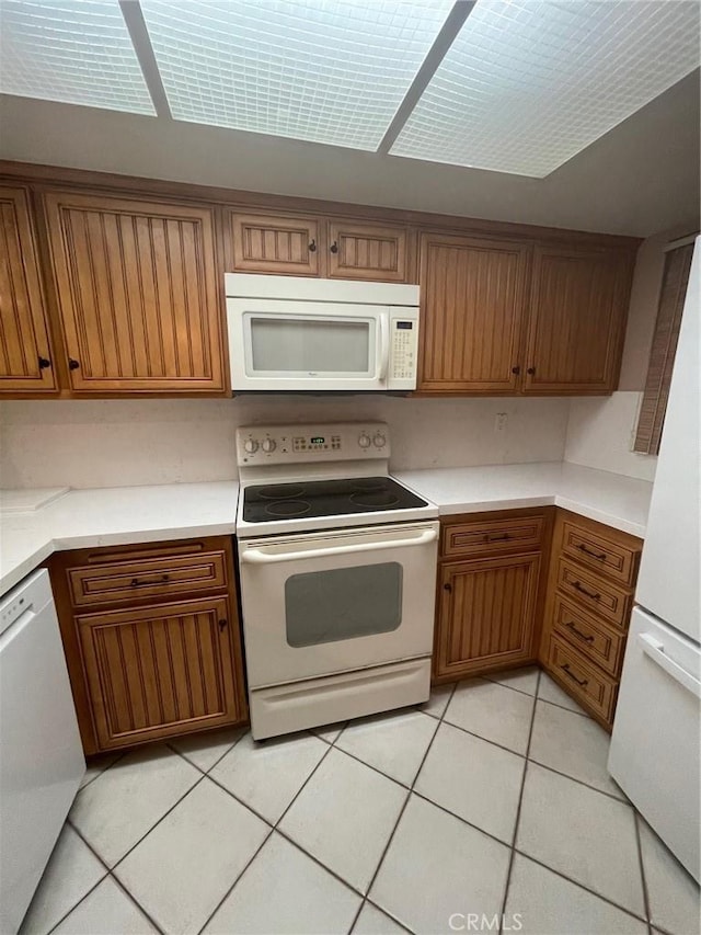 kitchen with light tile patterned floors and white appliances