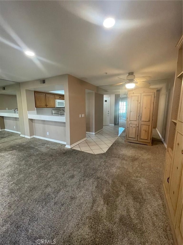 unfurnished living room with ceiling fan and light colored carpet