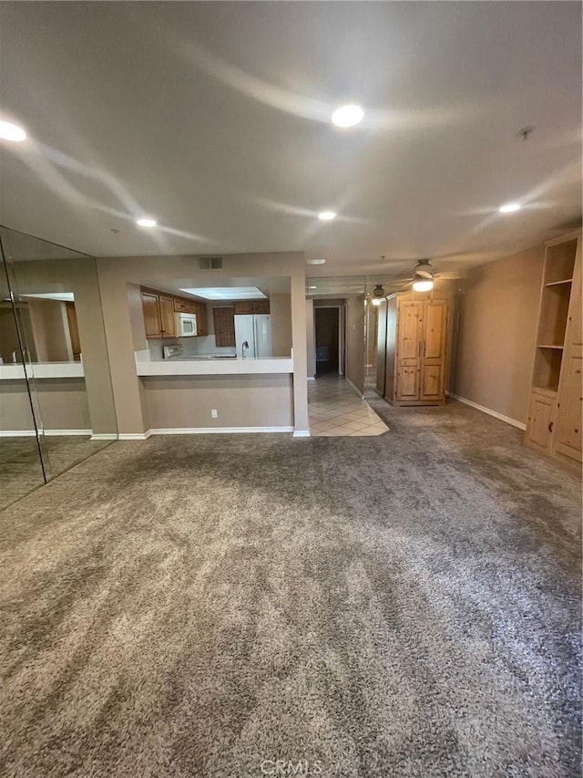 unfurnished living room featuring carpet and ceiling fan