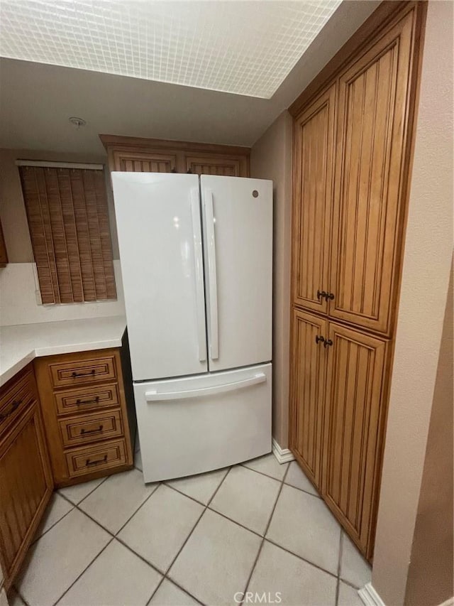 kitchen with light tile patterned floors and white fridge