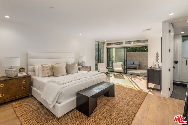 bedroom with light hardwood / wood-style flooring and expansive windows