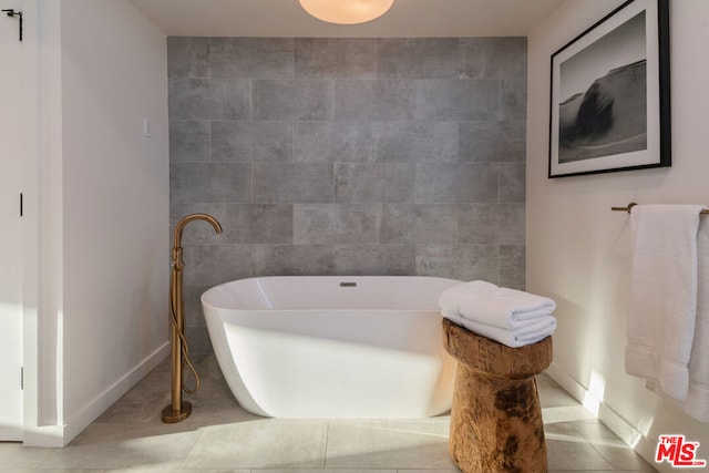 bathroom featuring tile walls, tile patterned floors, and a bathing tub