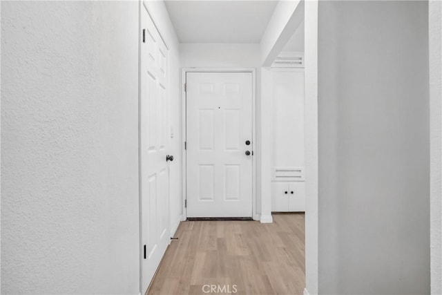 hallway with light hardwood / wood-style floors