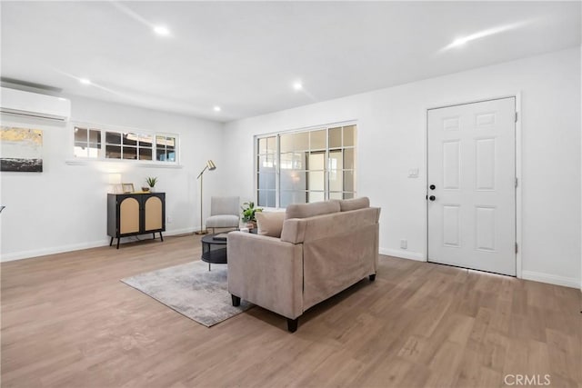 living room with light wood-type flooring and a wall mounted air conditioner