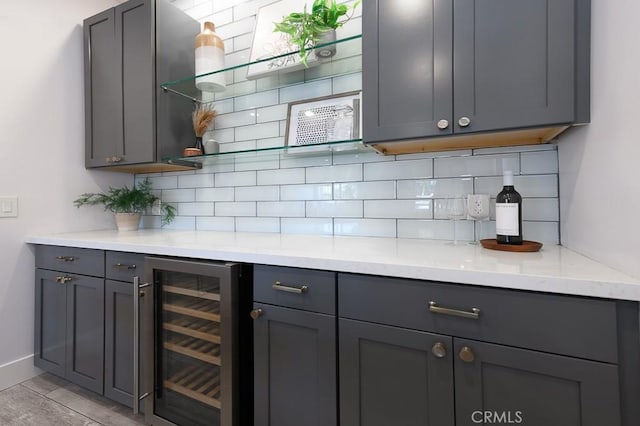 kitchen featuring decorative backsplash, gray cabinetry, and wine cooler