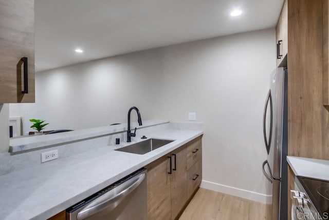 kitchen featuring stainless steel appliances, light hardwood / wood-style floors, and sink