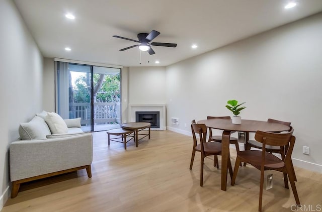 dining room with ceiling fan, light hardwood / wood-style flooring, and floor to ceiling windows