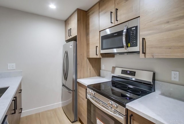 kitchen featuring appliances with stainless steel finishes and light hardwood / wood-style flooring