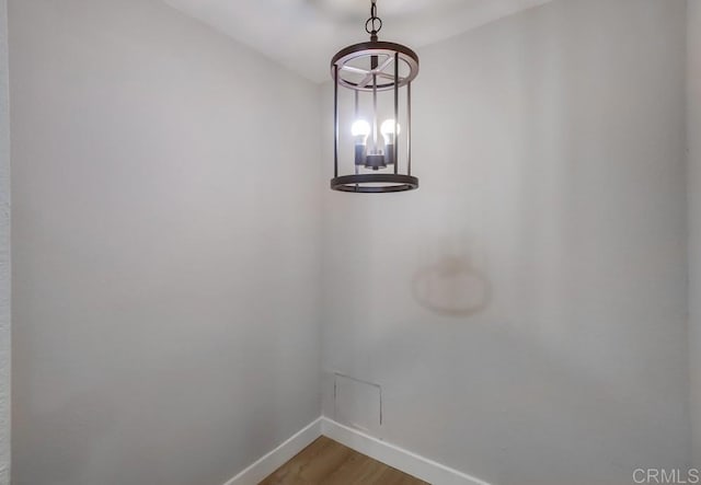 room details with wood-type flooring and a notable chandelier