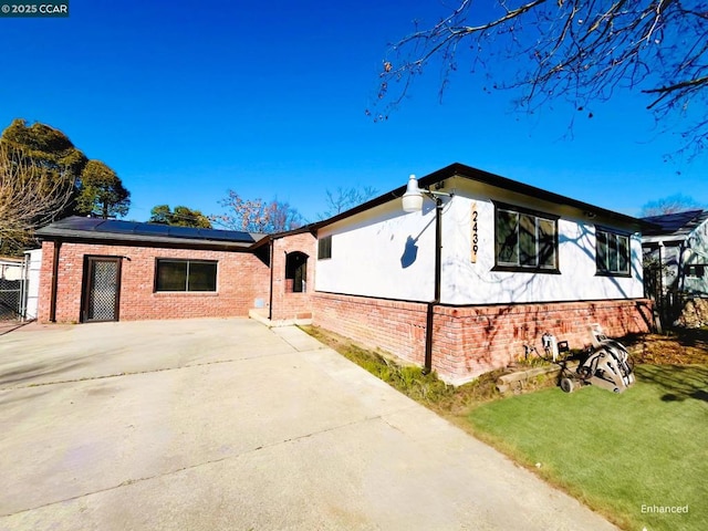 view of front of house featuring a front yard and solar panels