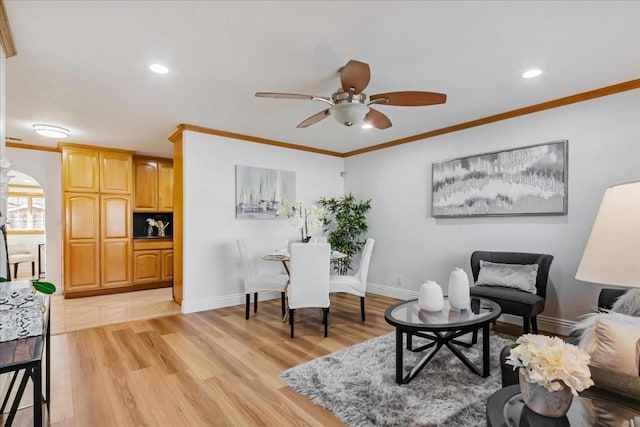 interior space with light wood-type flooring, ceiling fan, and ornamental molding