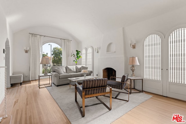 living room featuring vaulted ceiling and light hardwood / wood-style floors