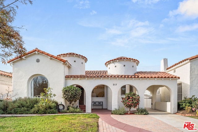 mediterranean / spanish-style house featuring a front lawn