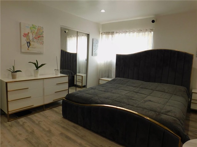 bedroom with a closet, recessed lighting, and wood finished floors