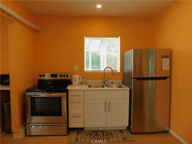 kitchen featuring a sink, white cabinetry, recessed lighting, appliances with stainless steel finishes, and light countertops