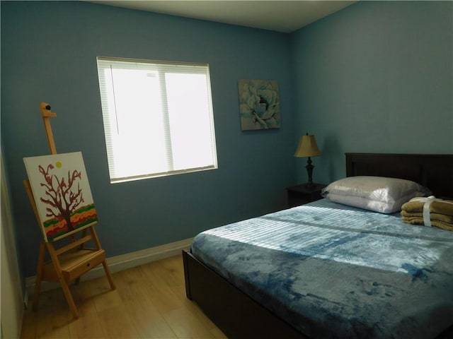 bedroom with baseboards and light wood finished floors