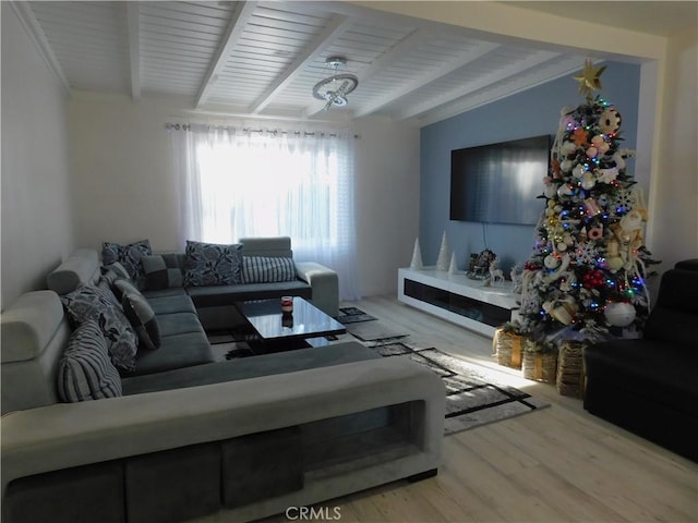 living room featuring beamed ceiling and wood finished floors