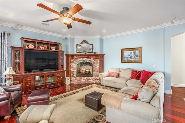 living area with crown molding, a ceiling fan, visible vents, and wood finished floors