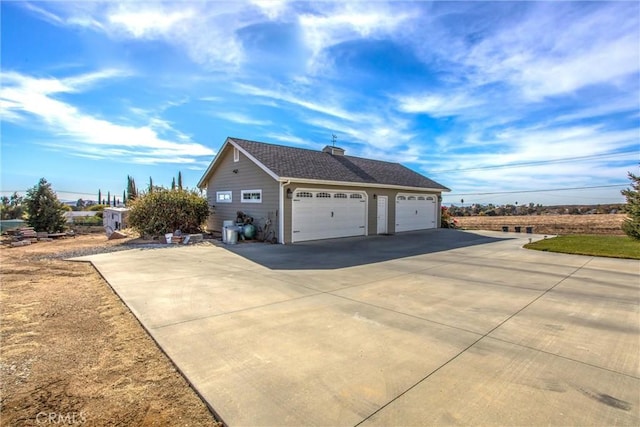 view of property exterior with a garage, a chimney, and concrete driveway