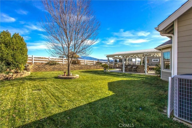view of yard with a fenced backyard, a mountain view, central AC, and a patio area